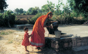a woman collecting water rom a well in Rajastan