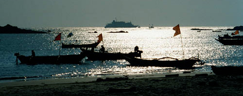 Silhouette of ship with Hodi boats
